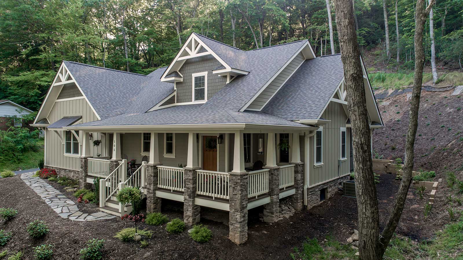 A large green North Carolina home built by Scroggs Construction is surrounded by trees
